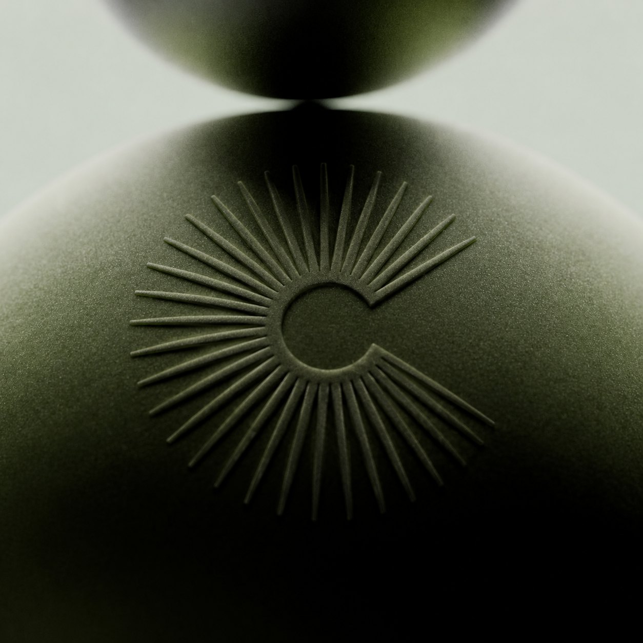 Optique Carnot – sun monogram embossed on a green ceramic form, branding by Jon Filin