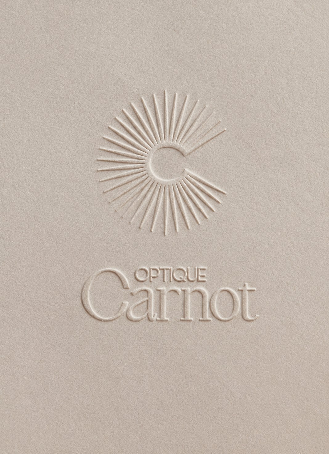 Optique Carnot – sun monogram and logotype blind-embossed on paper, branding by Jon Filin